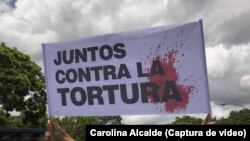 Un grupo de personas participa en una protesta para exigir DDHH en Venezuela, cuyo Estado enfrenta una investigación de la Corte Penal Internacional (CPI) por presuntos crímenes de lesa humanidad. 
