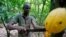 FILE: A man cuts a cocoa pod from a tree on a plantation in Toumodi, Ivory Coast on Oct. 13, 2018.