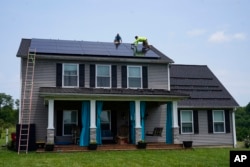 FILE - Solar panels are installed on the roof of a home in Frankfort, Ky., July 17, 2023. Residential solar is gaining traction in the U.S.