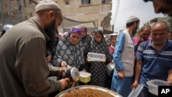Palestinians line up for food distribution in Deir al Balah, Gaza, May 10, 2024. 