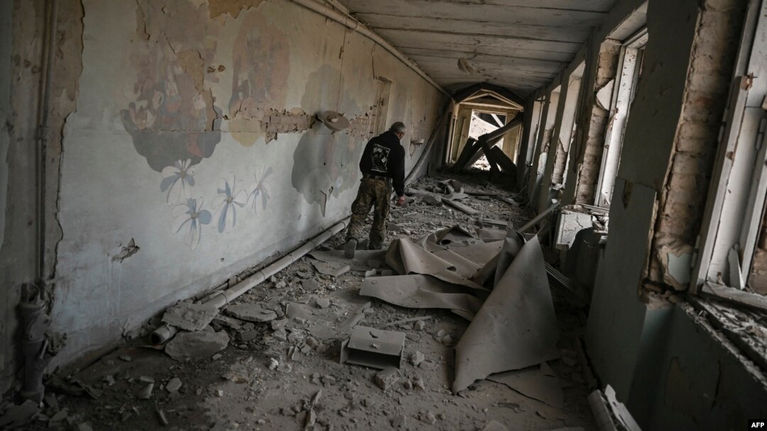A local resident walks inside a destroyed school after a strike in Chasiv Yar, west of Bakhmut, eastern Ukraine, March 22, 2023. 