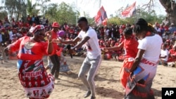 Nesta foto tirada na quarta-feira, 2 de outubro de 2019, apoiantes do partido no poder, Frelimo, dançam enquanto participam num comício eleitoral.