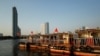 FILE - The Bangkok skyline is seen behind tourist boats on the Chao Phraya river in downtown Bangkok, Thailand, Feb. 4, 2021.