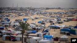 Palestinians displaced by the Israeli air and ground offensive on the Gaza Strip walk through a makeshift tent camp in Rafah, Gaza, May 10, 2024.