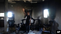 A Palestinian stands in his home the morning after it was torched in a rampage by Israeli settlers in the West Bank village of Jit, Aug. 16, 2024. 