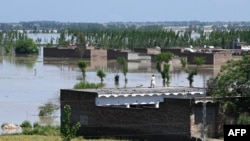 A man stands on the roof of his flood-damaged house after heavy rains in Nowshera district, Khyber-Pakhtunkhwa province in Pakistan, April 16, 2024.