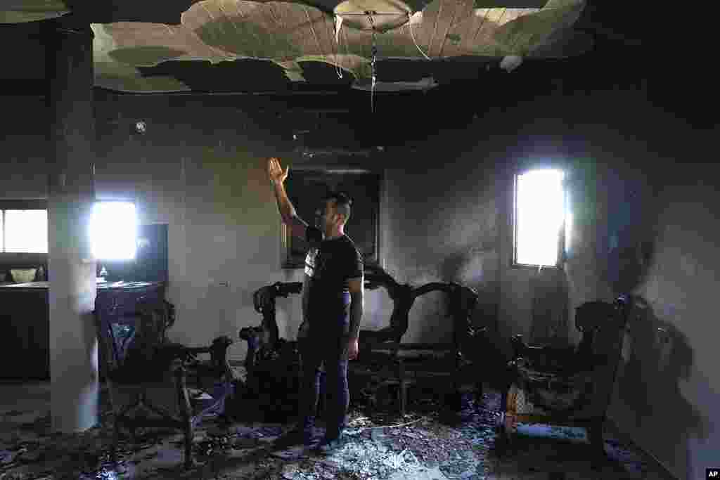 A Palestinian stands in his home the morning after it was torched in a rampage by Israeli settlers in the West Bank village of Jit.