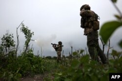 Ukrainian soldiers of the 28th Separate Mechanized Brigade fire a grenade launcher at the front line near the town of Bakhmut, Donetsk region, June 17, 2023.