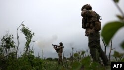 Ukrainian soldiers of the 28th Separate Mechanized Brigade fire a grenade launcher at the front line near the town of Bakhmut, Donetsk region, June 17, 2023. 