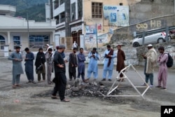 Penduduk setempat melihat tempat di mana massa Muslim menggantung dan membakar seorang pria atas tuduhan menodai kitab suci Islam, di Madyan, provinsi Khyber Pakhtunkhwa, Pakistan, Jumat, 21 Juni 2024. (AP/Naveed Ali)