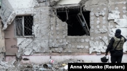 2022年12月1日烏克蘭赫爾鬆一名烏克蘭戰爭罪檢察官檢查一座俄羅斯軍事打擊而受損的住宅樓