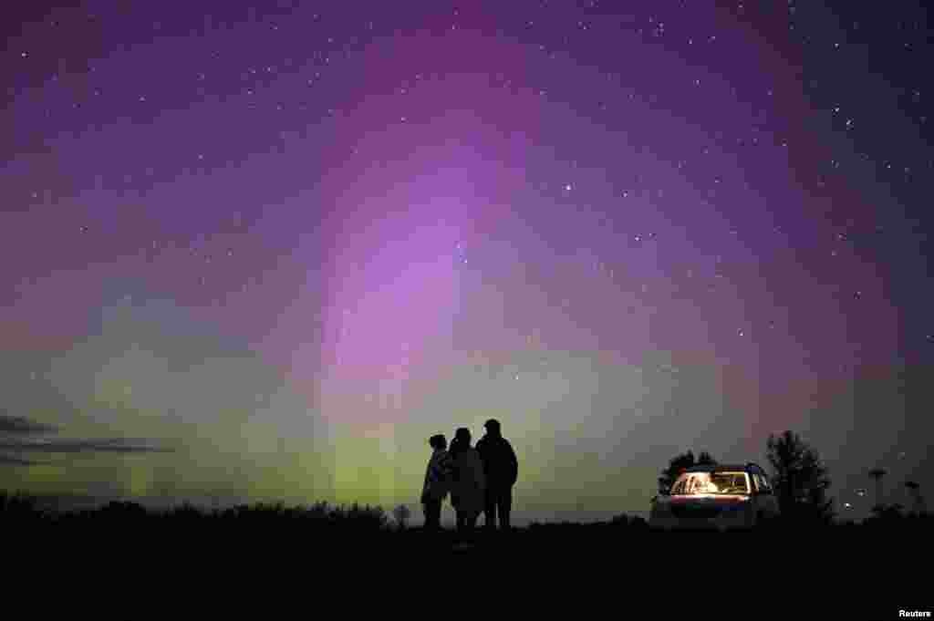 The Aurora Borealis, also known as the Northern Lights, illuminate the sky as people gather to watch the annual Perseid meteor shower near the village of Borodinka in the Omsk region, Russia.