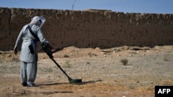FILE - This picture taken on Nov. 9, 2021 shows a deminer from the HALO (Hazardous Area Life-Support Organization) Trust scanning the ground for mines with a metal detector in Nad-e-Ali village in Helmand province. 