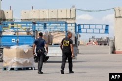Trucks carrying humanitarian aid wait for customs clearance at the Karm Abu Salem border crossing on March 14, 2024, amid ongoing conflict between Israel and the Palestinian militant group Hamas.