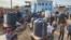 Palestinians queue to collect drinking water from a water treatment station in the central Gaza Strip to distribute to displaced people at shelters, in Deir al Balah, Gaza Strip, Oct. 27, 2023.