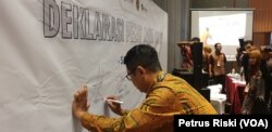 Yohanes Adven Sarbani, Koordinator Wilayah PESAT Jawa Timur, bersama para pihak menandatangani deklarasi PESAT, sebagai gerakan menghadirkan informasi sehat jelang Pemilu 2024. (Foto: Petrus Riski/VOA)