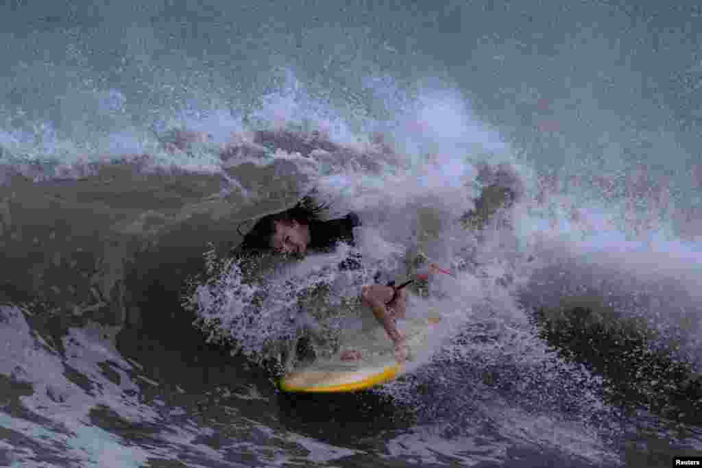 A surfer rides the swells ahead of Hurricane Idalia in Clearwater Beach, Florida, Aug. 29, 2023. 