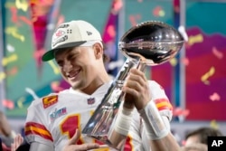 Quarterback Kansas City Chiefs Patrick Mahomes (15) mengangkat trofi setelah mengalahkan Philadelphia Eagles di Super Bowl 57, di Glendale, Ariz., Minggu, 12 Februari 2023. (AP/Matt Slocum)