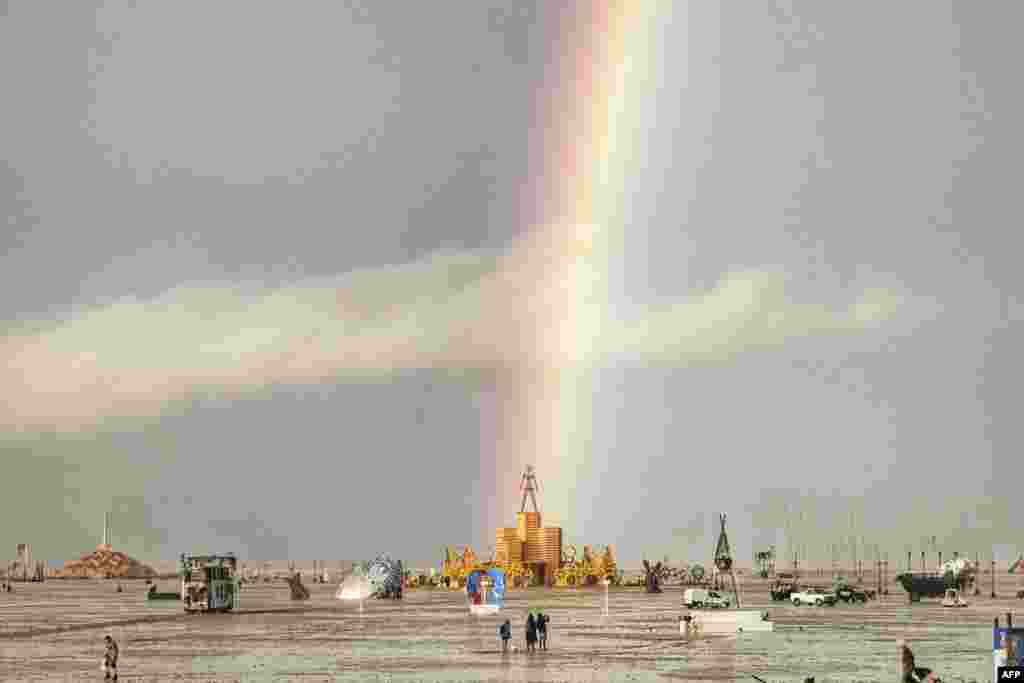 This handout image provided courtesy of Josh Lease shows a rainbow over flooding on a desert plain on Sept. 1, 2023, after heavy rains turned the annual Burning Man festival site in Nevada&#39;s Black Rock desert into a mud pit.&nbsp;&nbsp;All events at the counterculture festival, which drew some 70,000 people, were canceled after rain tore down structures for dance parties, art installations and other eclectic entertainment.&nbsp;