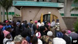 Travelers are seen in a queue outside the passport offices in Harare, Zimbabwe, Dec. 20, 2023. 