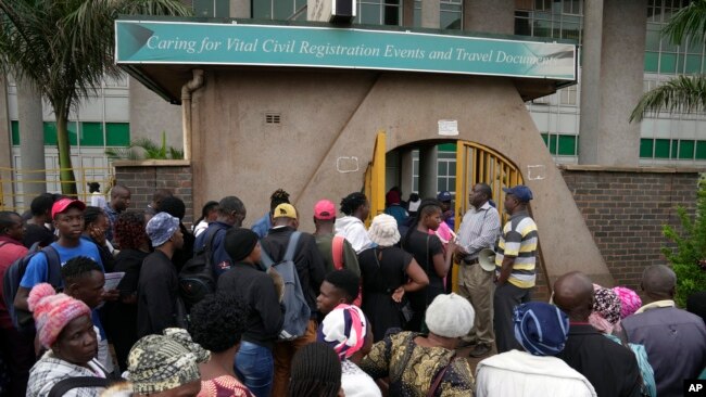 Travelers are seen in a queue outside the passport offices in Harare, Zimbabwe, Dec. 20, 2023.