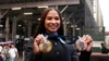 American gymnast Jordan Chiles shows her Olympic medals after ringing the closing bell at the Nasdaq MarketSite, in New York's Times Square, Aug. 8, 2024. 