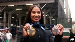 American gymnast Jordan Chiles shows her Olympic medals after ringing the closing bell at the Nasdaq MarketSite, in New York's Times Square, Aug. 8, 2024. 