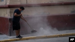 A man sweeps up volcanic ash spewed from the Popocatepetl volcano, in Atlixco, Mexico, May 24, 2023.