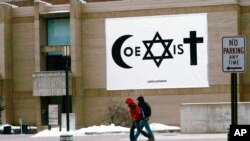 FILE - Students walk past a banner promoting diversity on the Atwood Memorial Center on the campus of St. Cloud State University, Jan. 16, 2008, in St. Cloud, Minn. 