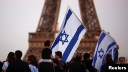 Pristalice Izraela drže zastave dok protestuju nakon najvećeg napada Hamasa na Izrael u posljednjih nekoliko godina, u Parizu, Francuska, 9. oktobra 2023., s Ajfelovim tornjem u pozadini.