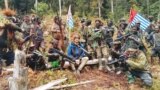 Con tin Philip Mehrtens, phi công người New Zealand, ngồi cùng quân ly khai vùng Papua, Indonesia, 6/3/2023.