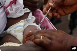 A health worker administers the malaria vaccine Oxford-Serum R21 to a child in Abidjan, Ivory Coast, Monday, July 15, 2024. (AP Photo/Diomande Ble Blonde)