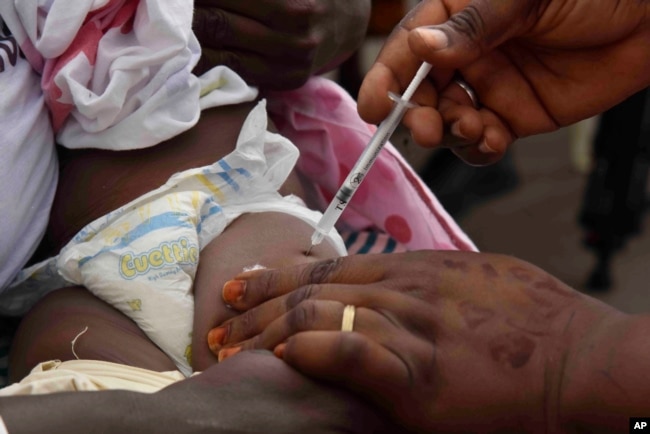 A health worker administers the malaria vaccine Oxford-Serum R21 to a child in Abidjan, Ivory Coast, Monday, July 15, 2024. (AP Photo/Diomande Ble Blonde)