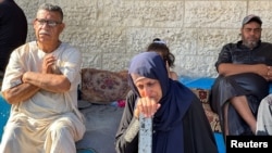 FILE - Mourners react next to the bodies of Palestinians (not pictured) killed in an Israeli strike, in Deir al-Balah in central Gaza Strip, May 24, 2024.