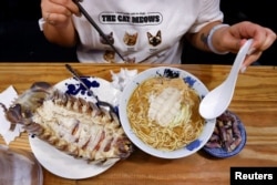 Digell Huang, 34, one of the two reserved customers tries the giant isopod ramen in Taipei, Taiwan May 27, 2023. (REUTERS/Ann Wang)