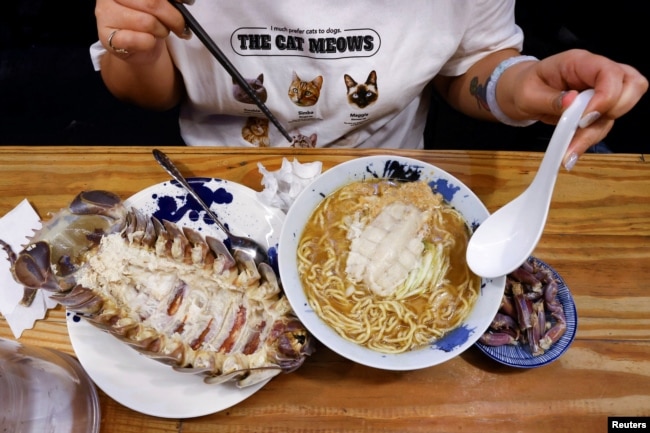 Digell Huang, 34, one of the two reserved customers tries the giant isopod ramen in Taipei, Taiwan May 27, 2023. (REUTERS/Ann Wang)