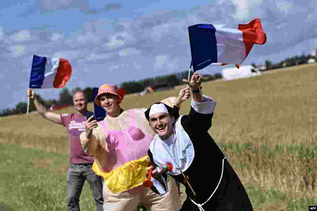 Spectators in costume wave French flags along the roadside during the 6th stage of the 111th edition of the Tour de France cycling race, 163,5 km between Macon and Dijon.