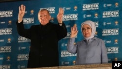 Turkish President and leader of the Justice and Development Party, or AKP, Recep Tayyip Erdogan, left, and his wife gesture to supporters at his party's headquarters in Ankara, Turkey, April 1, 2024.