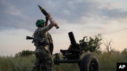 FILE - A Ukrainian serviceman fires a 122mm mortar towards Russian positions at the front line, near Bakhmut, Donetsk region, Ukraine, July 2, 2023. 