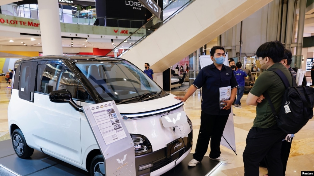 资料照片：在雅加达一家购物中心，一名推销员向顾客介绍中国制造的五菱电动汽车。(2023年2月5日）(photo:VOA)