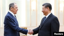 Chinese President Xi Jinping, right, shakes hands with Russian Foreign Minister Sergey Lavrov during their meeting in Beijing, China, April 9, 2024. (Russian Foreign Ministry/Handout via Reuters)