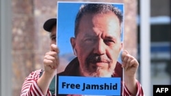 FILE - A demonstrator holds a picture of Iranian German dual national Jamshid Sharmahd, who has been sentenced to death in Iran, during a rally calling for his release by Tehran, in front of the German Foreign Ministry in Berlin, July 31, 2023.