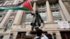 A student protester parades a Palestinian flag outside the entrance to Hamilton Hall on the campus of Columbia University in New York, April 30, 2024. (Mary Altaffer/Pool via Reuters)