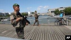 French soldiers patrol on a footbridge on the Seine river in Paris, July 17, 2024.