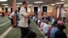 FILE - Yusuf Abdulle, standing, director of the Islamic Association of North America, prays with fellow Muslims at the Abubakar As-Saddique Islamic Center in Minneapolis, Minnesota, May 12, 2022.