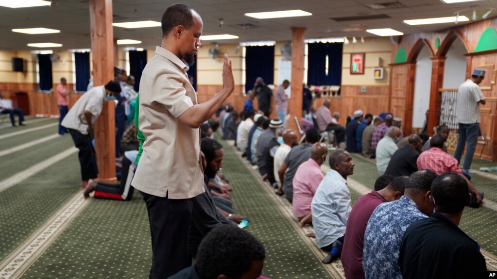 FILE - Yusuf Abdulle, standing, director of the Islamic Association of North America, prays with fellow Muslims at the Abubakar As-Saddique Islamic Center in Minneapolis, Minnesota, May 12, 2022.