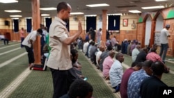 FILE - Yusuf Abdulle, standing, director of the Islamic Association of North America, prays with fellow Muslims at the Abubakar As-Saddique Islamic Center in Minneapolis, Minnesota, May 12, 2022.