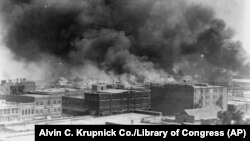 FILE - Smoke billows over Tulsa, Oklahoma, in this 1921 image provided by the Library of Congress.