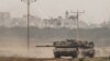 FILE - Israeli tanks re-enter Israel from Gaza, amid the ongoing conflict between Israel and the Palestinian Islamist group Hamas, near the Israel-Gaza border, in southern Israel, Jan. 11, 2024. 