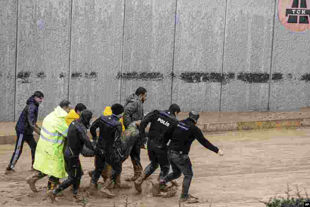 Полицијата и членовите на спасувачкиот тим носат тело на лице пронајдено за време на поплавите по обилните дождови, во Шанлиурфа, Турција.